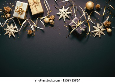 Christmas golden decoration with gift boxes on dark background. Template for greeting card - Powered by Shutterstock