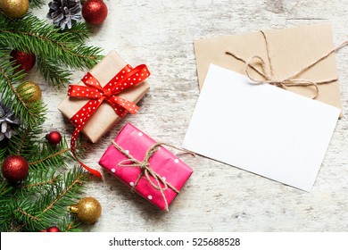 christmas greeting card with envelope on white wooden background with fir tree branches and happy new year decorations - Powered by Shutterstock