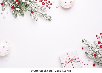 Christmas greeting card. Frame of Christmas decorations, gift and fir-tree. White background as copy space. Elegant classic style.