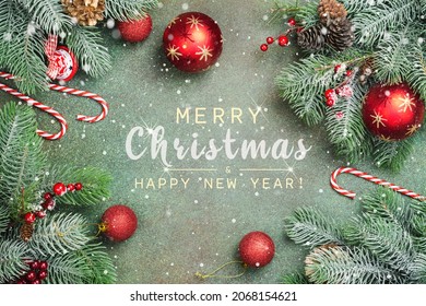 Christmas Greeting Card. Merry Christmas background with fir tree branches, candy canes and xmas balls decorations. Festive Xmas and New Year concept. Top view