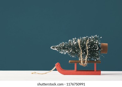 Christmas Greeting Card. Noel. Bright Christmas Tree Toy In The Form Of A Fir Tree On A Santa Claus Sleigh On A Dark Background. Front View. Copy Space. Happy New Year