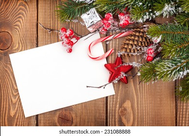 Christmas Greeting Card Or Photo Frame Over Wooden Table With Snow Fir Tree. View From Above