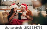 Christmas, happy couple and hug on sofa with hot chocolate, coco and relax in home. Man, woman and eggnog in living room for comfort, warmth and enjoy festive season in winter with love and support