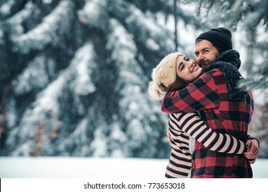 Christmas Happy Couple In Love Embrace In Snowy Winter Cold Forest, Copy Space, New Year Party Celebration, Holiday And Vacation, Travel, Love And Relations