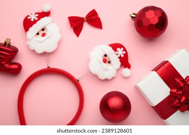 Christmas headband Santa Claus head design with white gift with red bow on pink background. Top view - Powered by Shutterstock