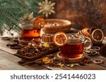 Christmas herbal tea with cinnamon, anise, and slices of dry citrus. Herbal tea with ingredients on a old wooden table.