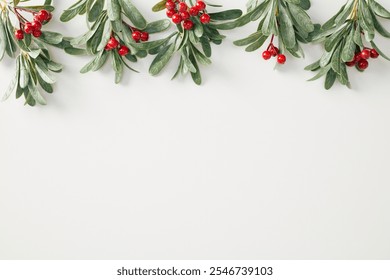 Christmas holiday background featuring green holly branches with red berries arranged along the top edge on a white surface. Ideal for Christmas and winter-themed designs. - Powered by Shutterstock