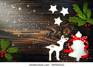 Christmas Holiday Background With Gingerbread Cookies And Fir Branches On The Old Wooden Board. Copy Space. Toned