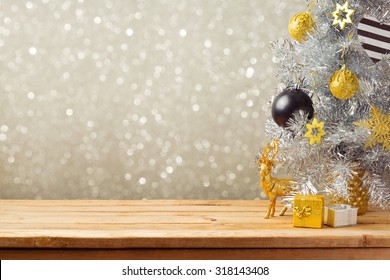 Christmas holiday background with Christmas tree and decorations on wooden table. Black, golden and silver ornaments