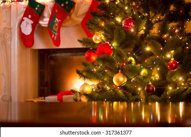 Christmas holiday background of wooden table against decorated Christmas tree and fireplace - Powered by Shutterstock