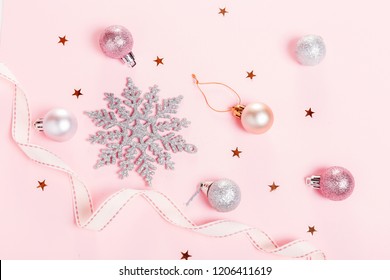 Christmas holiday composition. Festive creative gold silver pattern, xmas pink decor holiday ball with ribbon, snowflakes on pink background. Flat lay, top view