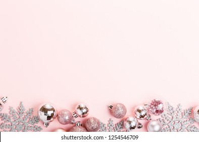 Christmas holiday composition. Festive creative gold silver pattern, xmas pink decor holiday ball with ribbon, snowflakes on pink background. Flat lay, top view