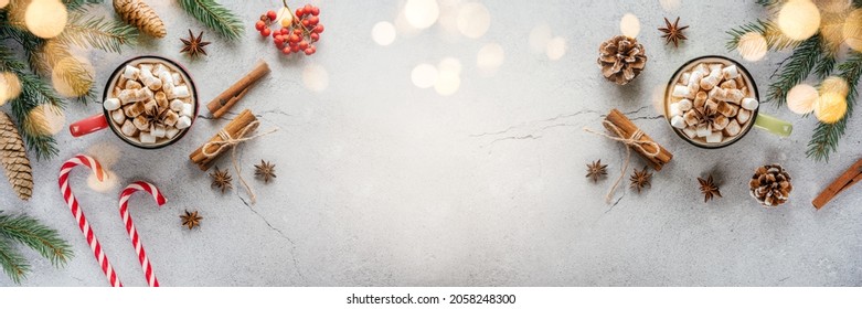 Christmas holiday creative layout with marshmallow hot chocolate, pine tree, red berries, candy canes, and pine cones, cosy Christmas flat lay