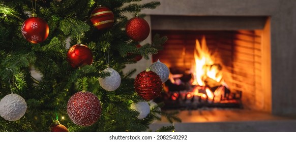 Christmas holiday home background. Warm cozy burning fireplace and Xmas tree decorated, season greetings card template, banner - Powered by Shutterstock