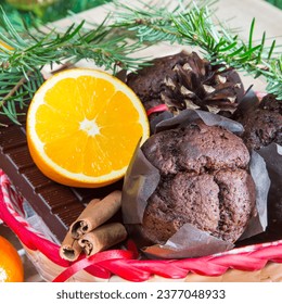 Christmas holiday still life with close up muffins, cinnamon sticks, oranges, chocolate and pine cone - Powered by Shutterstock