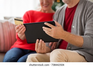 christmas, holidays and people concept - close up of happy smiling senior couple with tablet pc computer and credit card shopping online at home - Powered by Shutterstock