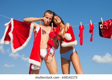 Christmas, holidays and people concept - happy couple in Santa hats exchanging gifts at home. Fashion red dress and sky background. Love story. Summer time concept. Romantic happy family. Love you. - Shutterstock ID 658142173