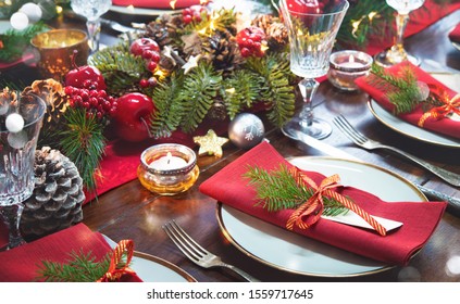 Christmas holidays table setting concept - wine glasses and tableware for festive dinner at home