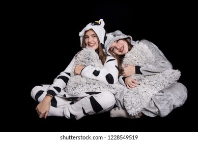 Christmas Holidays. Two Children, Sisters Are Wearing Animal Pajamas. Merry Christmas Or Halloween Concept. Family Holiday, Party Over Black Background. Cute Teenage Sisters. Teen. Hugging.