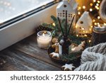 Christmas home aromatherapy. Aroma diffuser with pine extract, organic essential oil, cedar and spruce cone, cinnamon, anise, vanilla scent, candles, wooden table. Cozy atmosphere, winter inspiration