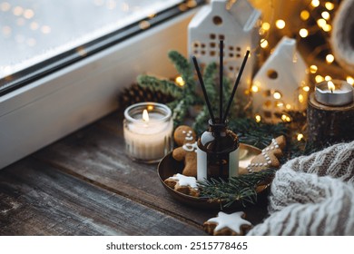 Christmas home aromatherapy. Aroma diffuser with pine extract, organic essential oil, cedar and spruce cone, cinnamon, anise, vanilla scent, candles, wooden table. Cozy atmosphere, winter inspiration - Powered by Shutterstock