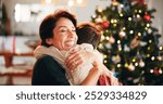 Christmas, house and hug with mother, son and bonding together with gift, decoration and care in lounge. Xmas tree, family and parent with boy, embrace and present with happiness, holiday and festive