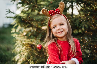 Christmas in july. Child waiting for Christmas in wood in july. portrait of little girl decorating christmas tree. winter holidays and people concept. Merry Christmas and Happy Holidays.