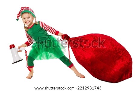 Christmas Kid pulling Santa Bag Full of Gifts. Funny Girl in Elf Costume with Red Huge Sack packed Xmas Presents. Happy Christmas Child with Megaphone. Winter Shopping and Package Delivery isolated