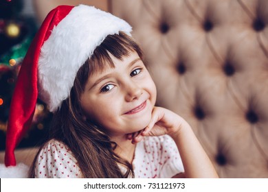 Christmas Kids,child, Portrait.Little Girl In Santa Claus Hat At Home With Xmas Tree.Close Up,selective Focus.