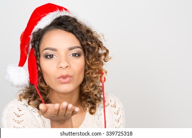 Christmas kisses. Beautiful cheerful female blowing kisses to the camera - Powered by Shutterstock