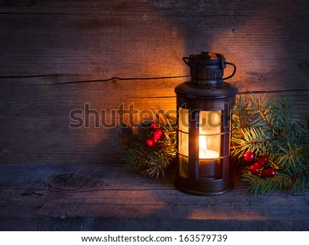 Christmas lantern  in night on old wooden background. focus on the wick candles