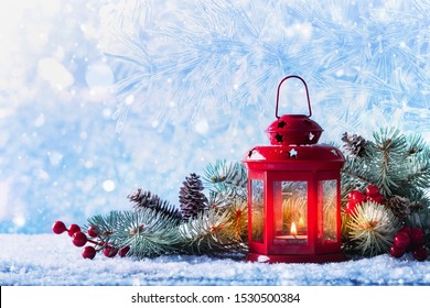 Christmas lantern in snow with fir tree branch. Winter cozy scene.