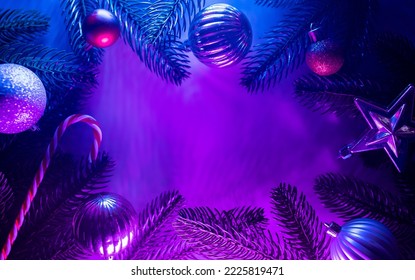 Christmas layout and christmas tree branches  christmas decorations in vibrant neon glow  copy space  top view  flat lay