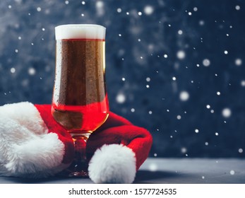 Christmas Light Beer Lager Beer In Glass With Santa Hat On Dark Background Copy Space