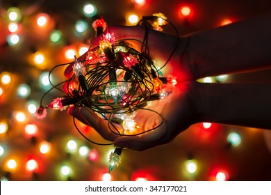 Christmas light bulbs in hands