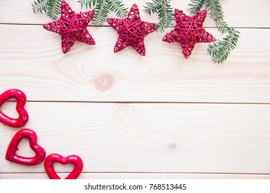 Christmas light wooden background with fir tree branches, glitter red wire stars and red hearts.. Close up. Copyspace - Powered by Shutterstock