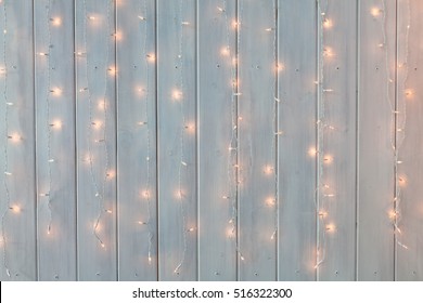 Christmas lights burning on a white wooden background. Xmas background. - Powered by Shutterstock