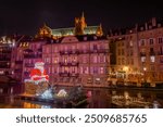 
Christmas lights in the city center of Metz, in Moselle. Decoration of shopping streets with electric garlands, Christmas balls  stars, a large fir tree and a Santa Claus on the Moselle river