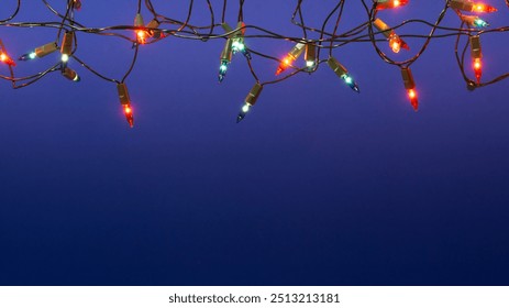 Christmas lights string on blue background with copy space - Powered by Shutterstock