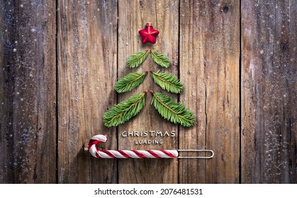 Christmas Loading Concept - Fir Tree And Candy Canes On Wooden Rustic Table