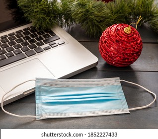 Christmas Lockdown, Office Closed, Covid 19 Pandemic. Protective Mask And Xmas Ornaments On Blue Wood Background, Season Holiday Business Desk