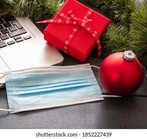 Christmas Lockdown, Office Closed, Covid 19 Pandemic. Protective Mask And Xmas Ornaments On Blue Wood Background, Season Holiday Business Desk