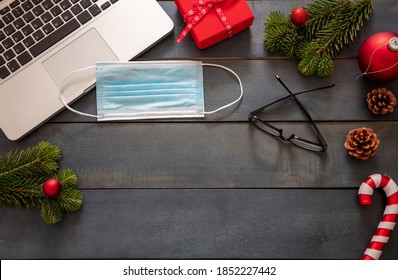 Christmas Lockdown, Office Closed, Covid 19 Pandemic. Protective Mask And Xmas Ornaments On Blue Wood Background, Business Desk Holiday Template, Copy Space