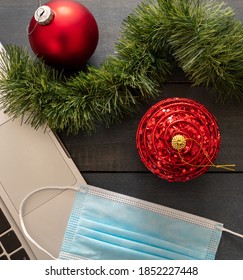 Christmas Lockdown, Office Closed, Covid 19 Pandemic. Protective Mask And Xmas Ornaments On Blue Wood Background, Season Holiday Business Desk