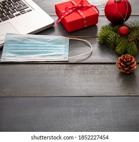 Christmas Lockdown, Office Closed, Covid 19 Pandemic. Protective Mask And Xmas Ornaments On Blue Wood Background, Business Desk Holiday Template, Copy Space