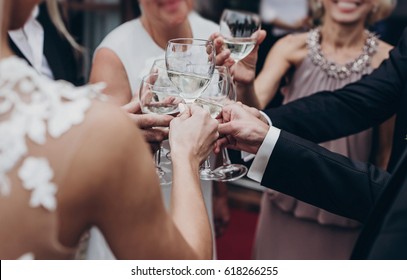 christmas luxury celebration feast. champagne and wine glasses in hands at luxury wedding reception at restaurant. guests toasting and cheering at stylish celebration. space for text