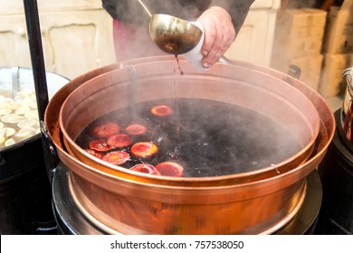 Christmas Market And A Pot Of Mulled Wine With Fruit And Spices