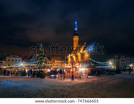 Christmas market in the town hall square in Tallinn. Holiday garlands and decorated Christmas tree in the old town. Trade tents with Christmas gifts and souvenirs.  Winter Estonia.