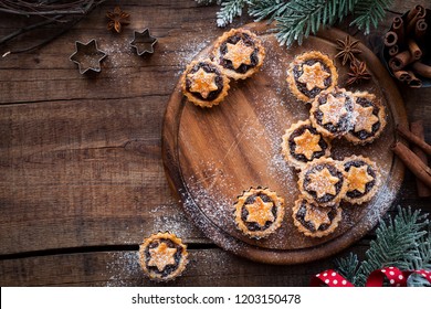 Christmas Mince Pies  On Wooden Cutting Board With Anise And Cinnamon Stick And Festive Xmas Decorations. Overhead View