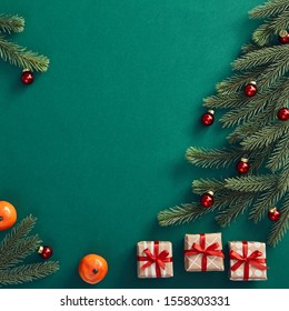 Christmas minimal concept - creative Christmas tree with red bauble and tangerine on dark green background. Copy space. Winter festive decoration. Christmas card concept.